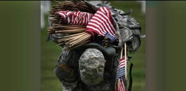 جندي من المارينز يعتل على كاهله الأعلام الأميركية